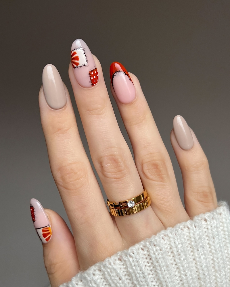 Amandelvormige nagels met nude en rood patchwork stitch-design